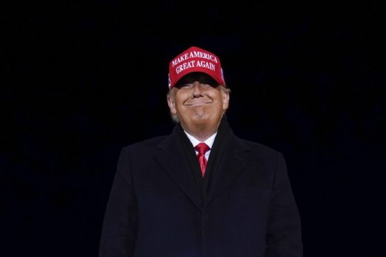 President Donald Trump smiles at supporters after a campaign rally at Gerald R. Ford International Airport, early Tuesday, Nov. 3, 2020, in Grand Rapids, Michigan.