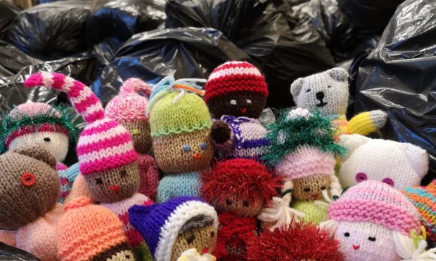 Knitted soft toys sit among the hundreds of bags of aid bound for Syria.
