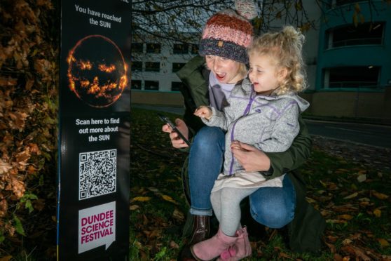 Mafalda Johnson and her daughter Milne, 3,  check out one of the QR codes on the trail across Dundee.