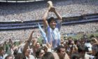 Diego Maradona holds up his team's trophy after Argentina's 3-2 victory over West Germany at the World Cup final at Atzeca Stadium in Mexico City.