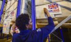 UK Aid stickers are placed on to cargo pallets containing British aid items destined for areas suffering humanitarian crisis at DFID's UK Disaster Response Operations Centre at Cotswold Airport, Kemble.