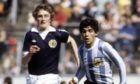 Scotland and Dundee United defender Paul Hegarty attempts to chase down Argentina legend Diego Maradona, who passed away today aged 60.