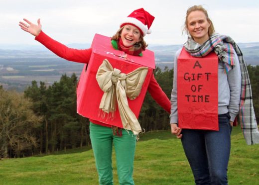 Anya Hart Dyke and her friend Ruth Nicolle promoting The Gift of Time idea by climbing Hill of Tarvit.