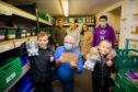 Kaeden Esslemont visiting the foodbank to donate the funds - front left is Kaeden alongside foodbank manager Norman Brown and sister Rhian - back row, left to right is dad Iain, mum Emma and sister Shannon, with foodbank volunteer Jamie Samson