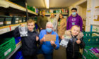 Kaeden Esslemont visiting the foodbank to donate the funds - front left is Kaeden alongside foodbank manager Norman Brown and sister Rhian - back row, left to right is dad Iain, mum Emma and sister Shannon, with foodbank volunteer Jamie Samson