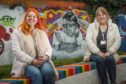 Brooke Reid (left) at the mural of her daughter, Freya Skene, with toy recycle organiser Lucie Conway.