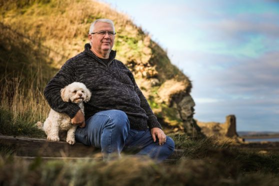 Ian Barnett at the harbour with his dog Betty.