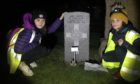 Two of the Cupar Scouts at one of the war graves in Cupar Cemetery where Remembrance respects were paid
