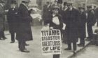 London newspaper seller with banner announcing the loss of SS Titanic in 1912.