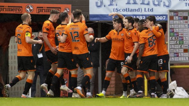 Liam Smith is mobbed by teammates after scoring his first goal for United.