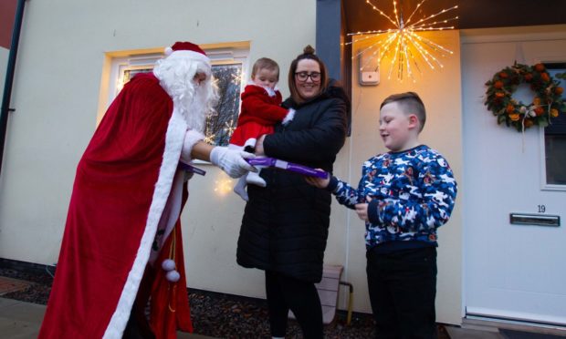 David Fiddes as Santa visiting Kim Fullerton and her children  Xander, 7, and Arlo, 10 months.


....Pic Paul Reid