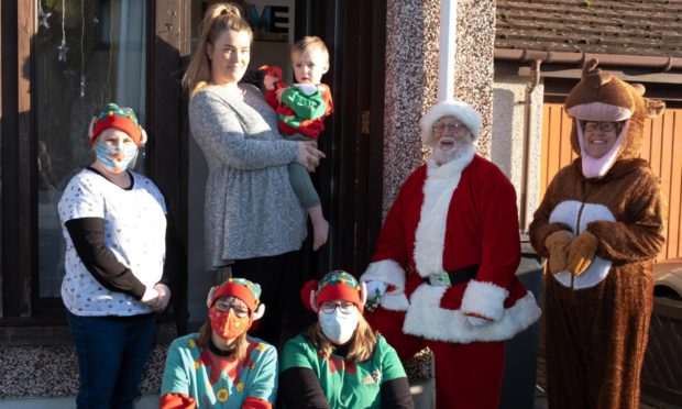 Kim Marr delivering Christmas goodies to mums in Arbroath. 
Picture shows Mum Nadia Hawley with son Benny(2) and L to R: Pamela Ramsay, Louise Smith, Tracy Bedwell Santa Claus and Kim Marr.
Picture: Paul Reid.