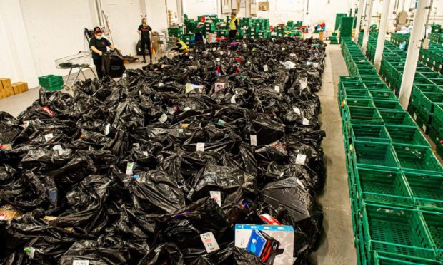 The green boxes are for families, and each black bag is filled with presents for a child.