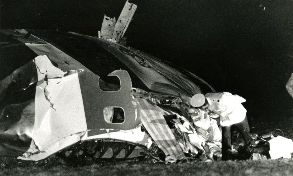 A policeman has a closer look at the nose of the stricken aircraft.