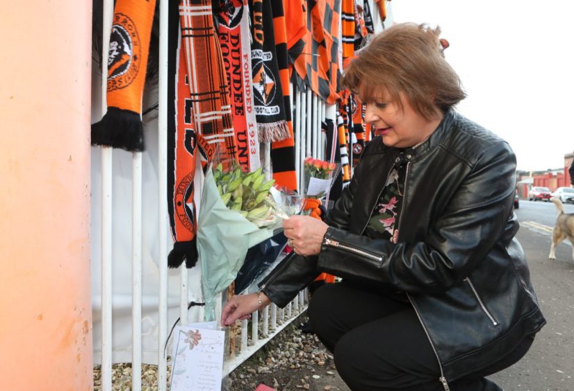 Lynn Coleman leaves flowers at the gates of Tannadice.