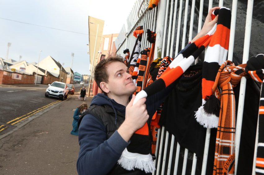 Kris Bissell, 27, ties a scarf on the gate.