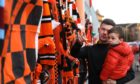 Andrew Baxter and Ayden look at the tributes to Jim McLean at Tannadice.