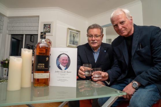 John Barr Jnr and Kris Nickolic with a bottle of 'John Barr' branded whisky. The pair plan to open the rare bottle and toast the memory of their dad/father-in-law -John Barr Snr - at his funeral this week.