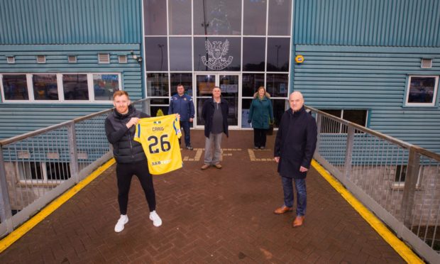 Liam Craig's shirt, auctioned off by Derrick Allan, front right, has raised £1,000 for Letham4all.