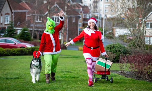 Caroline Behaghel de Bueren (as The Grinch) and Carolann Fraser (as Wonder Woman) with dog Monkey.