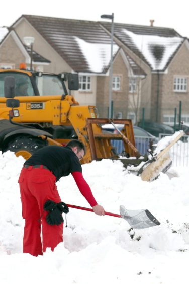 A man begins clearing the grounds of Kinnaird Primary School, as the cold weather continues on March 3 2018.