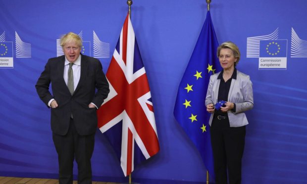 Britain's Prime Minister Boris Johnson is welcomed for a dinner with European Commission president Ursula von der Leyen, right, in Brussels.