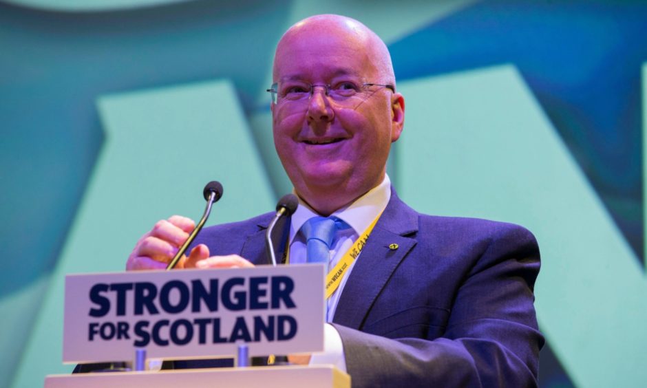 Peter Murrell at a podium with the slogan 'Stronger for Scotland' written on it.
