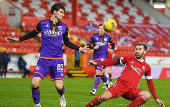 United's Ian Harkes with Niall McGinn of the Dons.