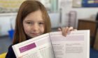 P6 pupil Keira Scott with the Education Scotland book.