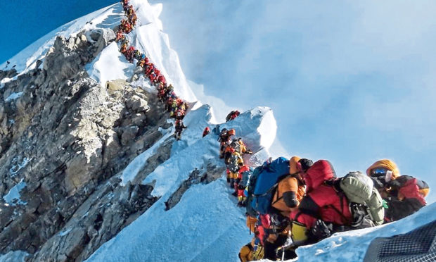 A long queue of mountain climbers line a path on Mount Everest in 2019.