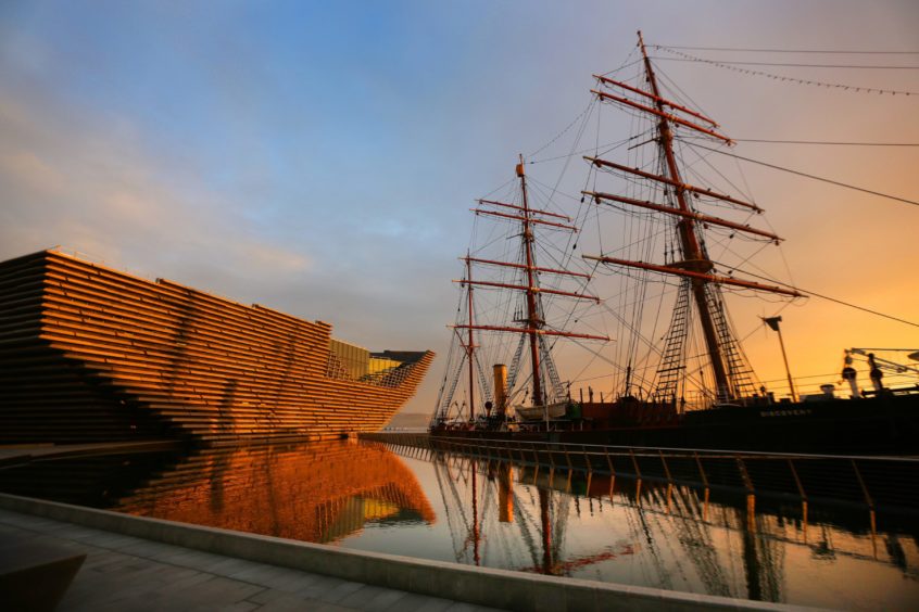 RRS Discovery in front of the V&A Dundee at sunset.
