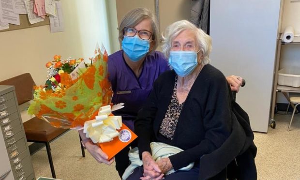 Edith Dean receives birthday flowers from Westgate Medical Practice nurse Valerie Dowds Christie