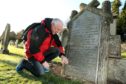 Local researcher Steve Nicoll at the Gray family headstone in Brechin cemetery.