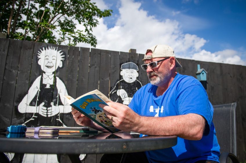 Jackie Handy at home researching which character he will add to his mural, Ballater Place, Dundee. Kim Cessford / DCT Media.