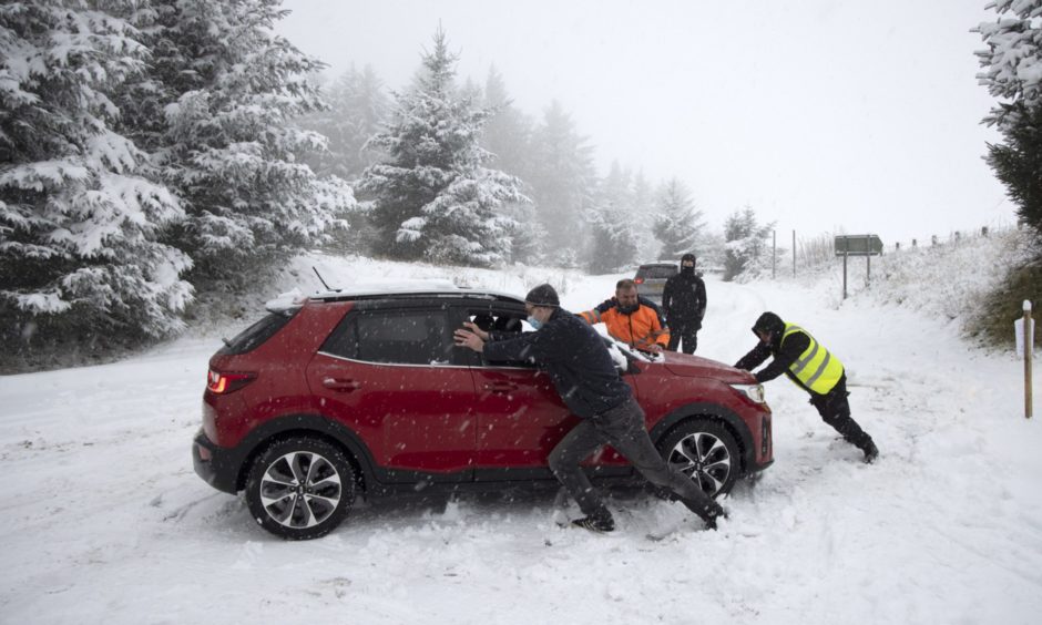 Passersby help a NHS worker stuck in the snow at the junction between the A9 and the road to Findo Gask.