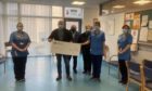 Peter Comrie with Jack and Madge McCowan give a cheque in memory of Jackie McCowan to staff at the oncology unit at Perth Royal Infirmary.