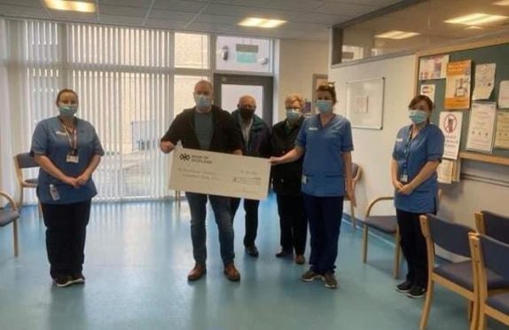 Peter Comrie with Jack and Madge McCowan give a cheque in memory of Jackie McCowan to staff at the oncology unit at Perth Royal Infirmary.
