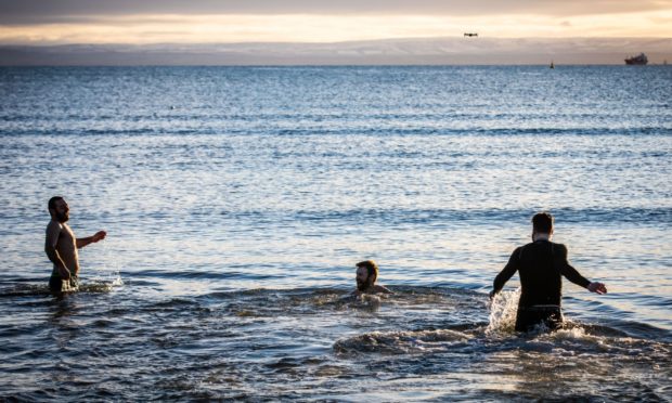 New Year Dookers Andrew Davies (36), John Wilson (35) and Davie Frew (30) make a splash at Ravenscraig Beach in Kirkcaldy.