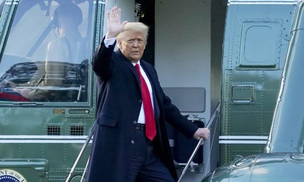 President Donald Trump waves as he boards Marine One on the South Law.