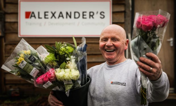 John Alexander, of Alexander's Community Development, with free flowers.