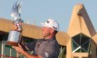 Lee Westwood surveys the trophy under the steely glare of the Abu Dhabi clubhouse eagle.