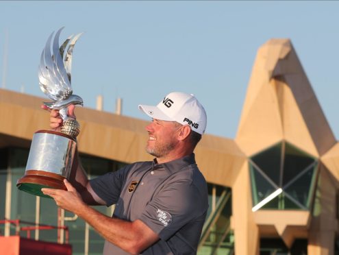 Lee Westwood surveys the trophy under the steely glare of the Abu Dhabi clubhouse eagle.