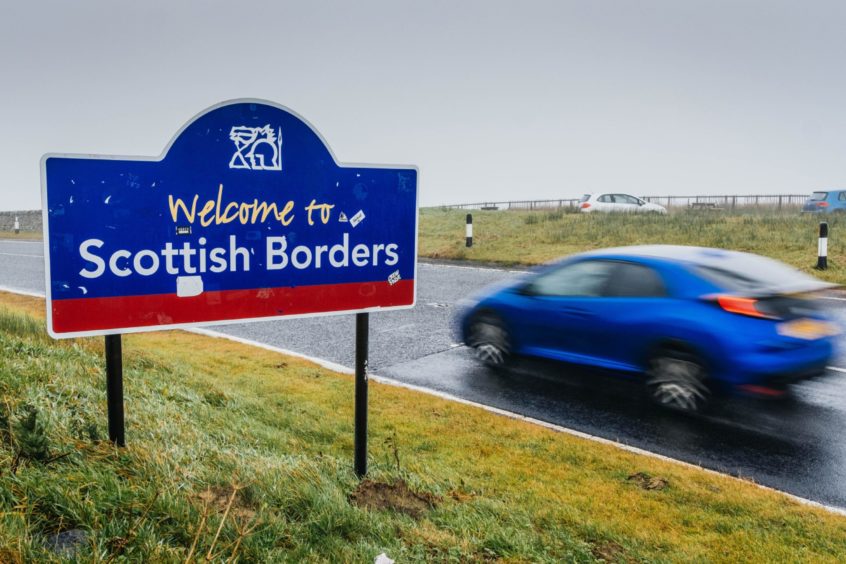 photo shows a car driving past a sign saying Welcome to Scottish Borders