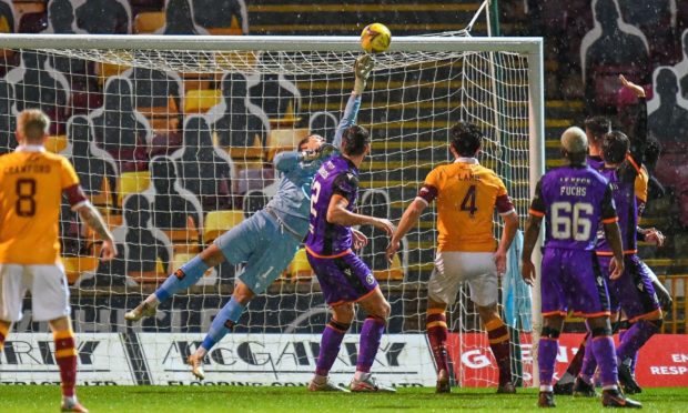 Benjamin Siegrist makes a big save from Motherwell defender Bevis Mugabi.