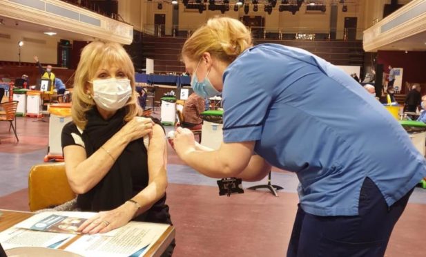 Margaret Scott receiving her vaccination at the Caird Hall from vaccinator Suzy Black.