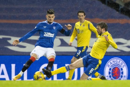 Rangers' Ianis Hagi (L) is tackled by St Johnstone's Murray Davidson.