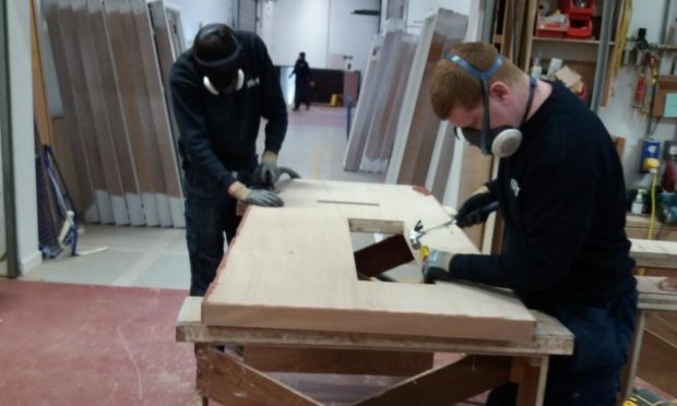 Corey Forsyth and Martin Wallace, first year joiners with Fife Council. They are carrying out tasks in the process of manufacturing a FD60 fire-resistant door. This work is completed in the councils purpose-built Joinery workshop at Bankhead, Glenrothes.