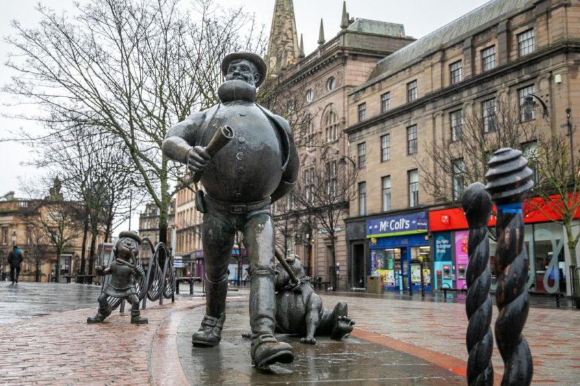 photo shows the Desperate Dan and Minnie the Minx statues in a deserted Dundee city centre on a rainy day.