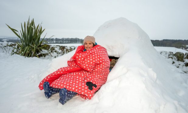 Delilah Frampton, all wrapped up outside her igloo.