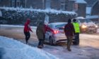 Good Samaritans helping to push cars on an icy curve of Glasgow Road, Perth. Pic: Steve MacDougall